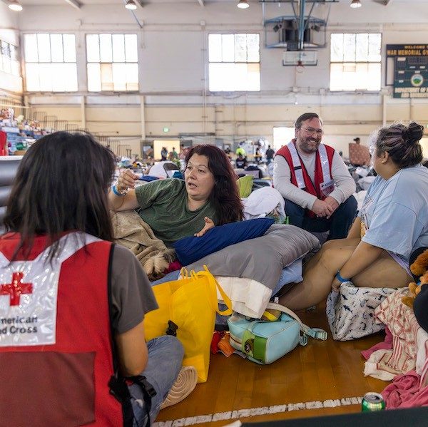 Two Red Cross volunteers having a conversation with shelter residents in HI