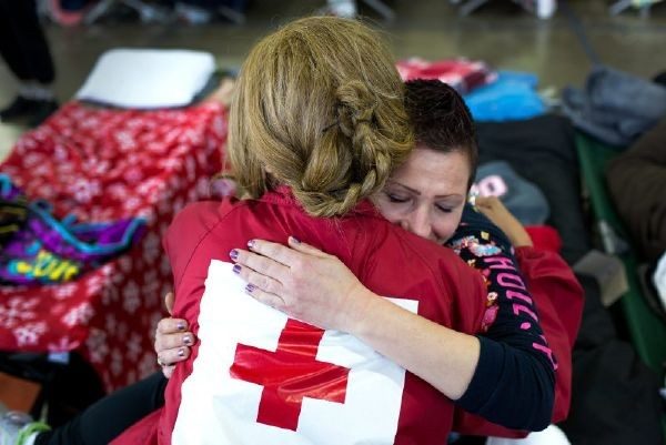 red crosser hugging woman